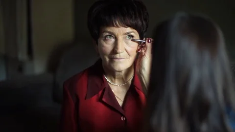 Professional make-up. Makeup artist doing makeup for an elderly woman Stock Footage 106381149