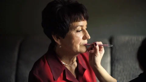 Professional make-up. Makeup artist doing makeup for an elderly woman Stock Footage 106384947