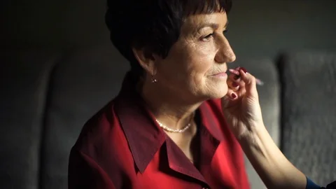 Professional make-up. Makeup artist doing makeup for an elderly woman Stock Footage 106386727
