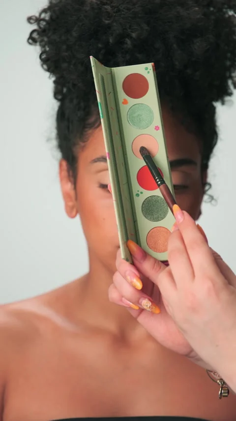Professional make-up master applies paint to a young model with curly hair Stock Footage 270801979