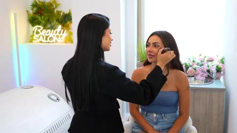 Professional makeup artist applying foundation on client's face Stock Footage 313531809