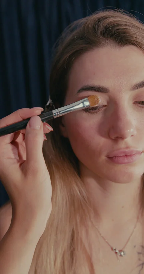 Professional makeup artist applying shimmery eyeshadow 動画素材 347010853