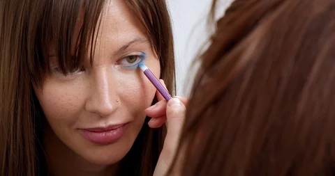 Professional makeup artist does makeup of young model. Close-up view of make-up Stock Footage 126356356