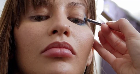 Professional makeup artist does makeup of young model. Close-up view of make-up Stock Footage 126356423