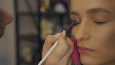 Professional makeup artist making eye-makeup for young model Vídeos de archivo 101022394