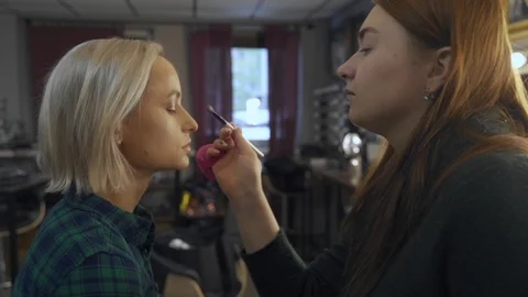 Professional makeup artist making eye-makeup for young model Vidéo 101022584