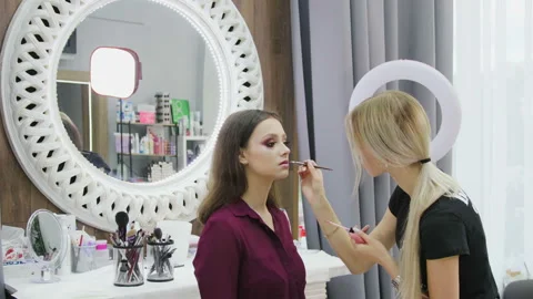 Professional makeup artist working on young girl creating natural look in beauty Vídeos de archivo 115429778