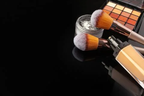 Professional makeup brushes and tools, make-up products set on dark table Stock Photos