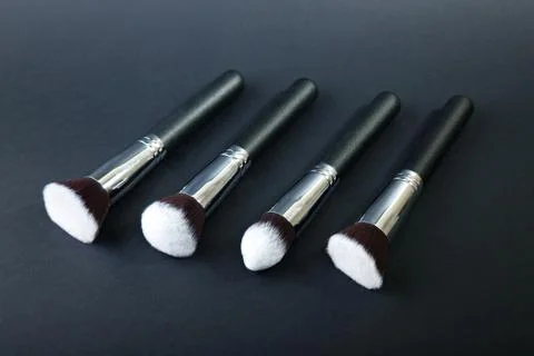 Professional makeup brushes on a black background, natural cloth Stock Photos