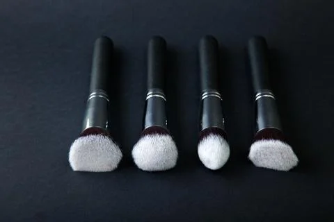 Professional makeup brushes on a black background, natural cloth Stock Photos