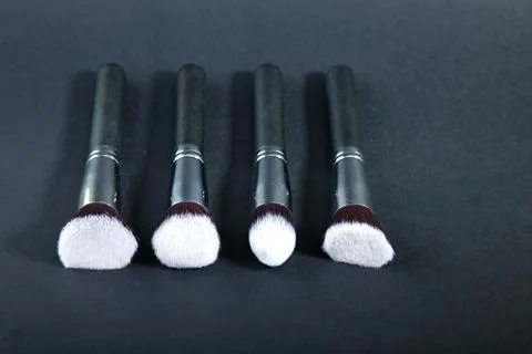 Professional makeup brushes on a black background, natural cloth Stock Photos