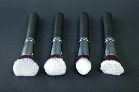 Professional makeup brushes on a black background, natural cloth Stock Photos