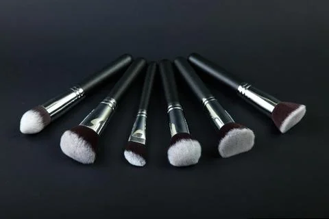 Professional makeup brushes on a black background, natural cloth Stock Photos