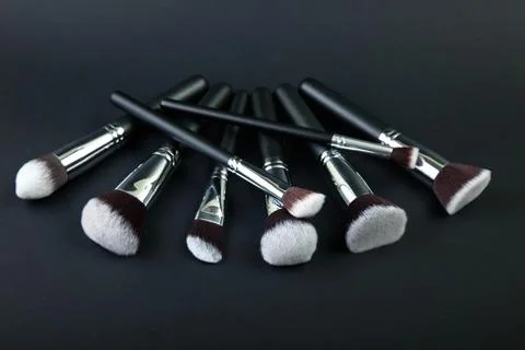 Professional makeup brushes on a black background, natural cloth Stock Photos