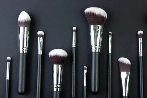 Professional makeup brushes on a black background, natural cloth Stock Photos