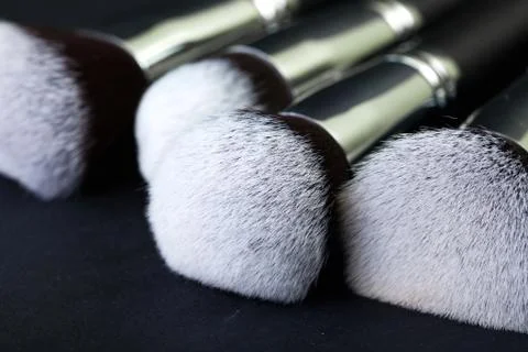 Professional makeup brushes on a black background, natural cloth Stock Photos