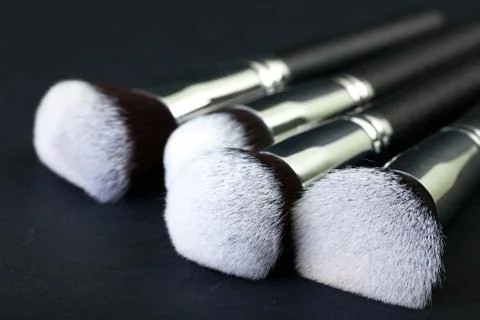 Professional makeup brushes on a black background, natural cloth Stock Photos