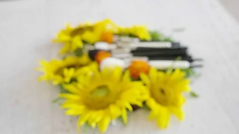 Professional makeup brushes on a table next to spring flowers Stock Footage