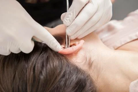 Professional making rook piercing in the ear Stock Photos