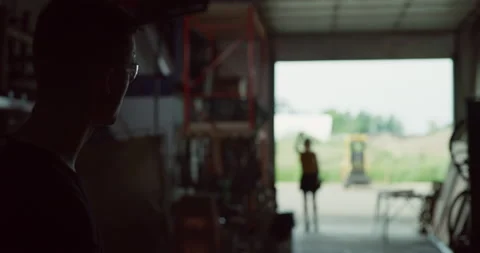 Professional male blacksmith hammering a piece of metal and goes over to greet c Video stock 199463531