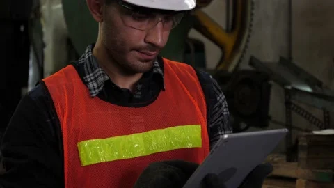 Professional male caucasian engineer using tablet and look up to the machine Stock Footage 147975456