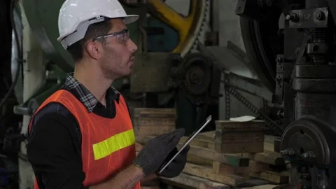 Professional male caucasian engineer using tablet and look up to the machine Stock Footage 147975460