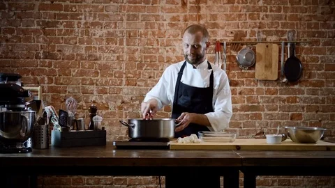 The professional male chef getting the boiled potatoes out of the saucepan. 4K Stock-Footage 82829505
