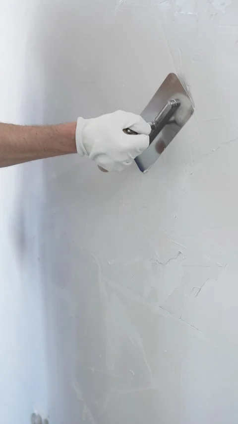 Professional male construction worker is using a finishing trowel to carefully Stock Footage 310402176