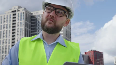 Professional male engineer in hard hat using laptop at construction site Stock Footage 334035466