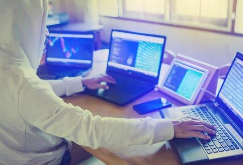 Professional male hacker using multiple computers ,tablet and smartphone for  Stockfoto's