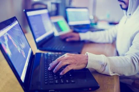 Professional male hacker using multiple computers ,tablet and smartphone for  Stockfoto's