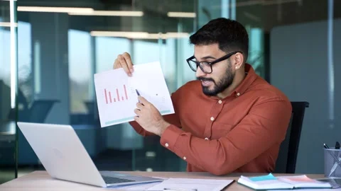 Professional male manager presenting chart data by video call using laptop while Stock Footage 305656149