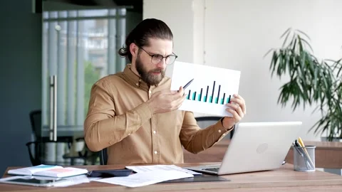 Professional male manager presenting chart data by video call using laptop while Stock Footage 321130301