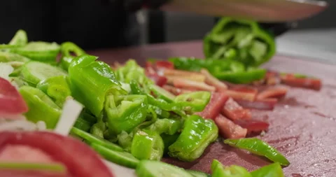Professional male prepares dish, chops green bell pepper. Colorful vegetables on Stock Footage 286835544