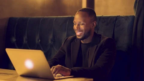 Professional male working remotely laughing out loud at his laptop 動画素材 144201854