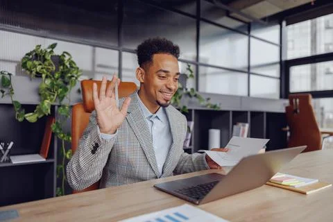 A Professional Man Actively Engaging in a Virtual Meeting Set in a Modern Office Stock Photos