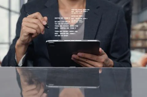 Professional Man Analyzing Binary Code on a Tablet Device 写真素材
