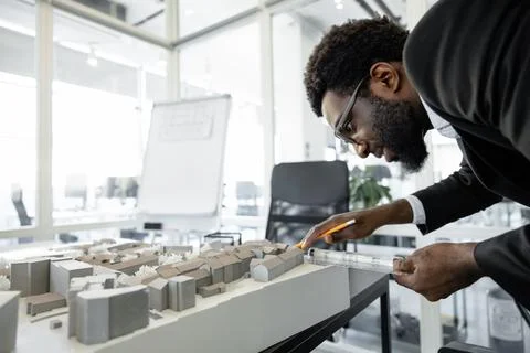 Professional man architect solving engineering problems in his workplace Stock Photos