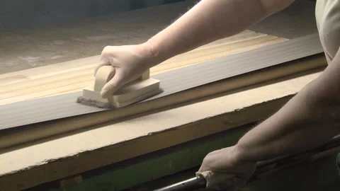 Professional man carpenter using belt sander machine, polishing wood product at Stock Footage 147078424