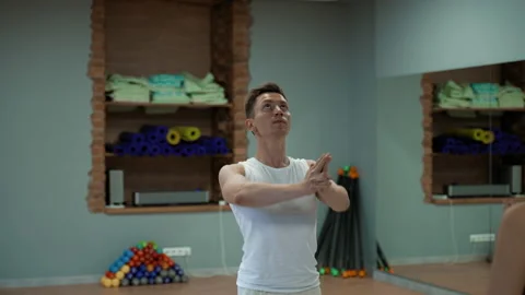 Professional man coach practices yoga with women students Stock Footage 208045347