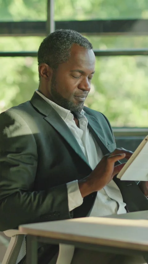 A professional man diligently working with a tablet in a modern, innovative Stock Footage 314362459