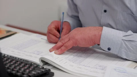 Professional man engaged in meticulous documentation, writing in a ledger with a Stock Footage 323231758