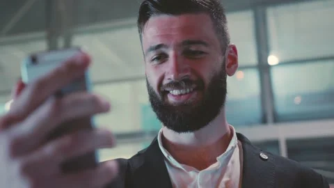 A Professional Man Engaging Actively with a Smartphone in a Modern Setting and Stock Footage 345495555