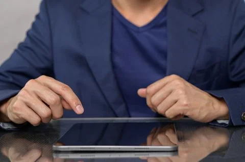 Professional Man Engaging with Tablet Device in Office Setting Stock Photos