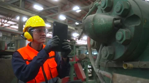 Professional man engineer analyzing meeting with tablet in factory warehouse. Видео 332119445
