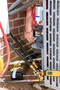 Professional man is fixing a unit of central air conditioning system Stock Photos