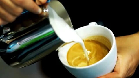 Professional man hand pouring stream milk for making espresso latte art. 動画素材 334649914