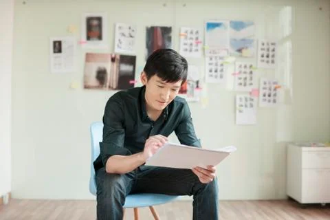 Professional Man Looking at Papers in Office Stock Photos