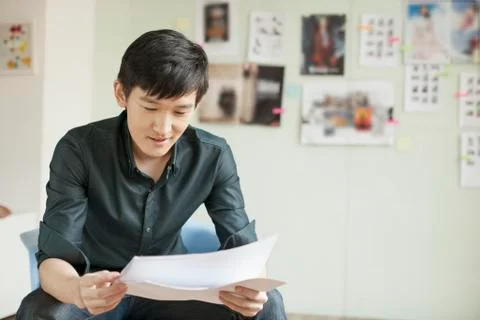 Professional Man Looking at Papers in Office Stock Photos