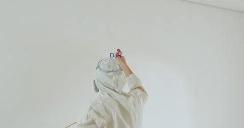 Professional man painter paints the walls with white paint spray gun. Repair of Stock Footage 242599267